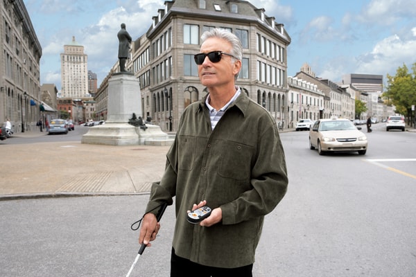 Man walking outdoors independently with a GPS device